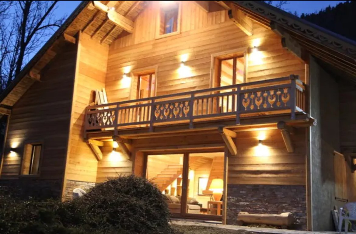 La façade du chalet illuminée en soirée
